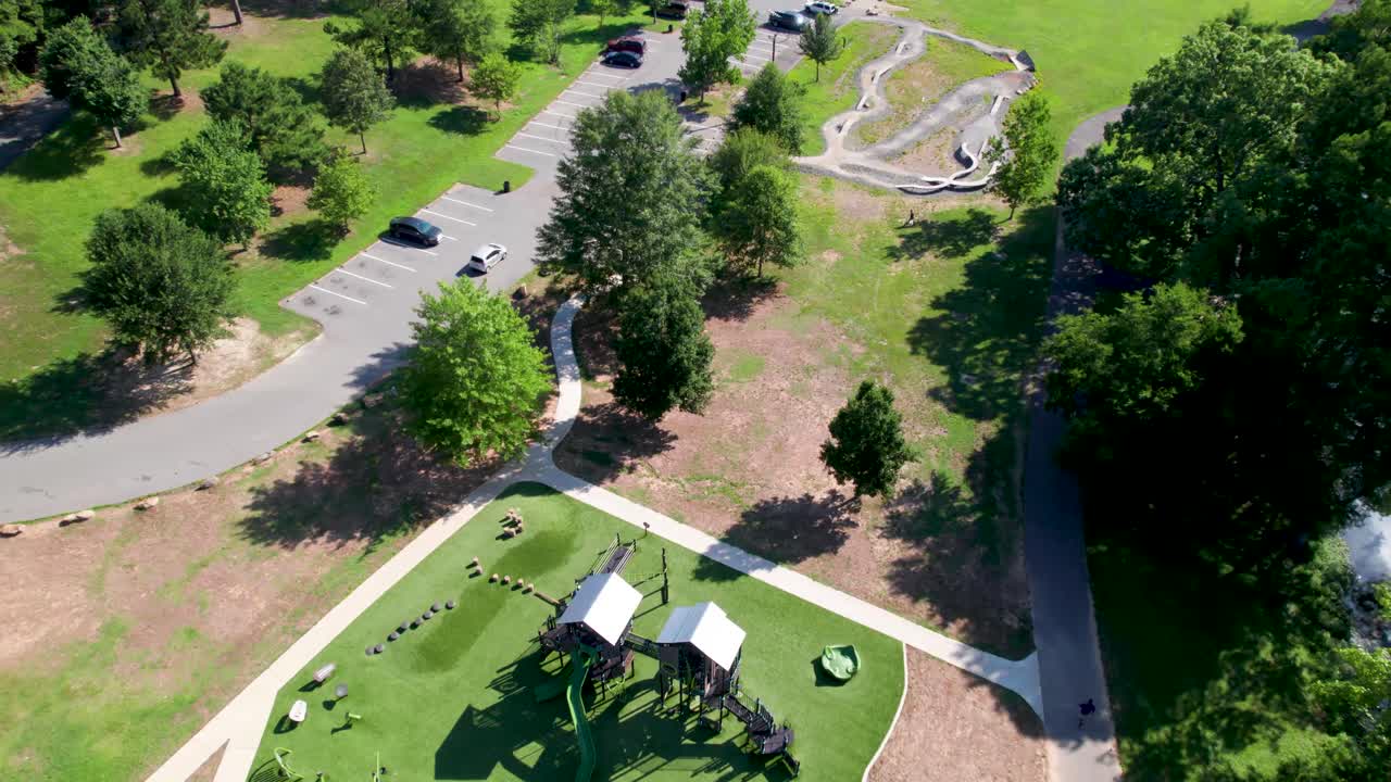 Aerial footage of Boyle Park playground in Little Rock Arkansas. Camera flies over playground and trails