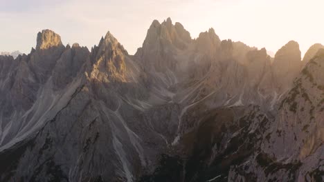 drone reveals ridgeline overlooking cadini group mountains in italian dolomites