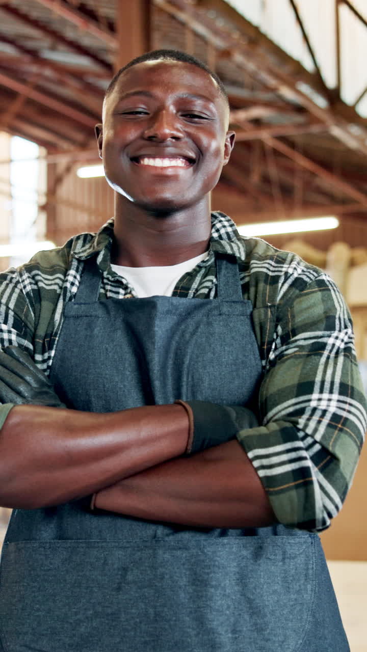 Homem negro jovem sorrindo com os braços cruzados na oficina