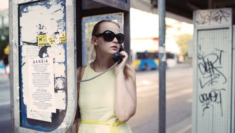 woman chatting on a public telephone