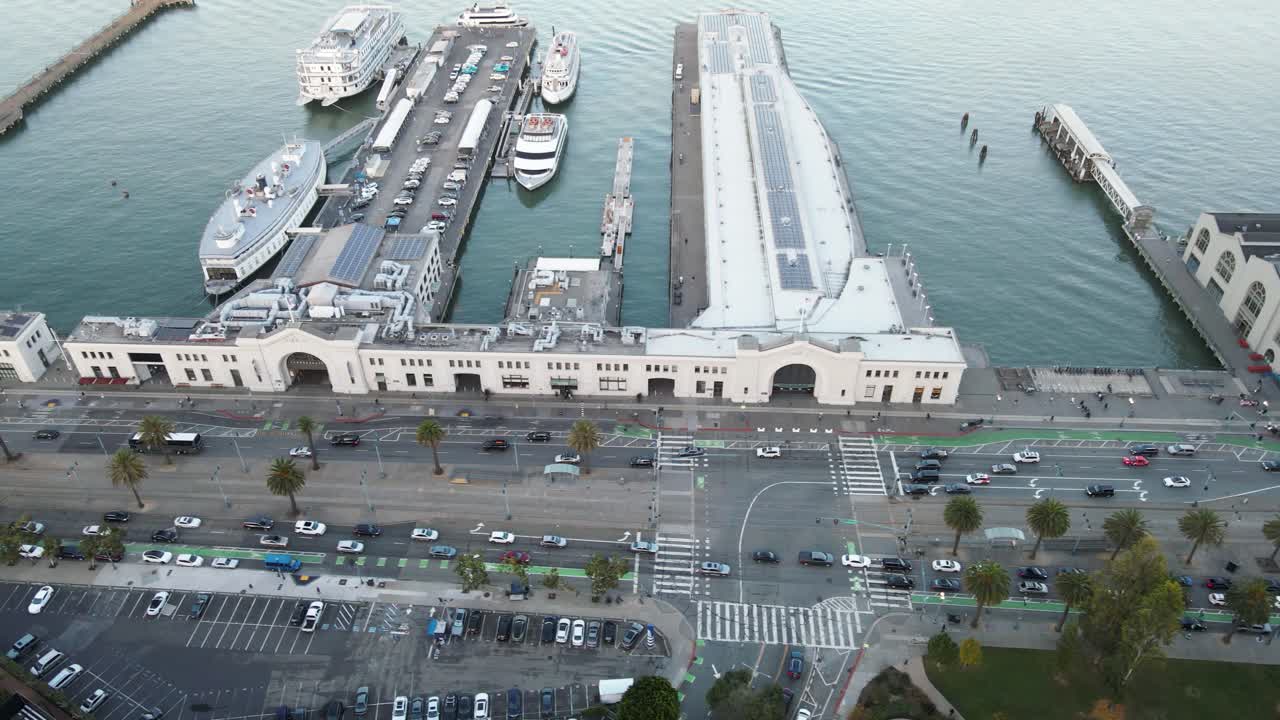Aerial view of a waterfront with piers, boats, and a parking lot, showcasing urban coastal infrastructure