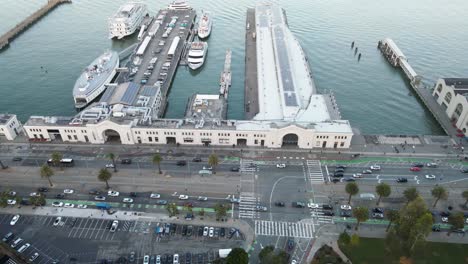 aerial view of a waterfront with piers, boats, and a parking lot, showcasing urban coastal infrastructure