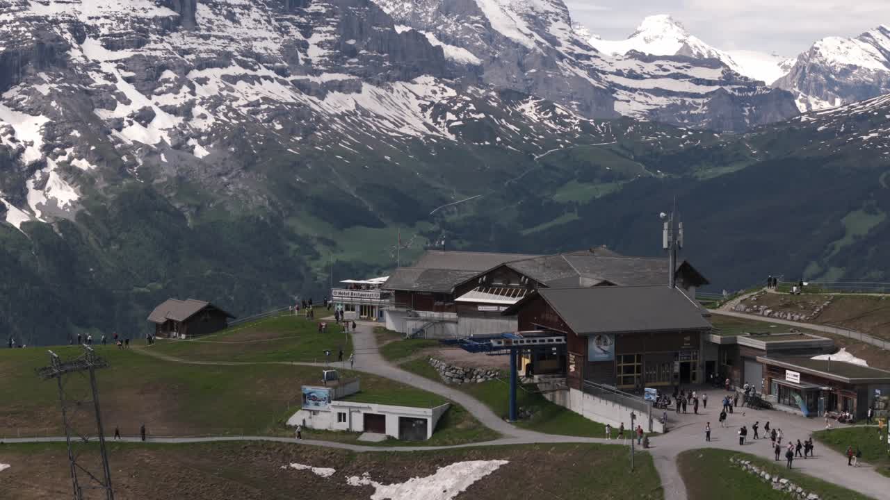 Panoramic view of a mountain resort with snowy peaks and people