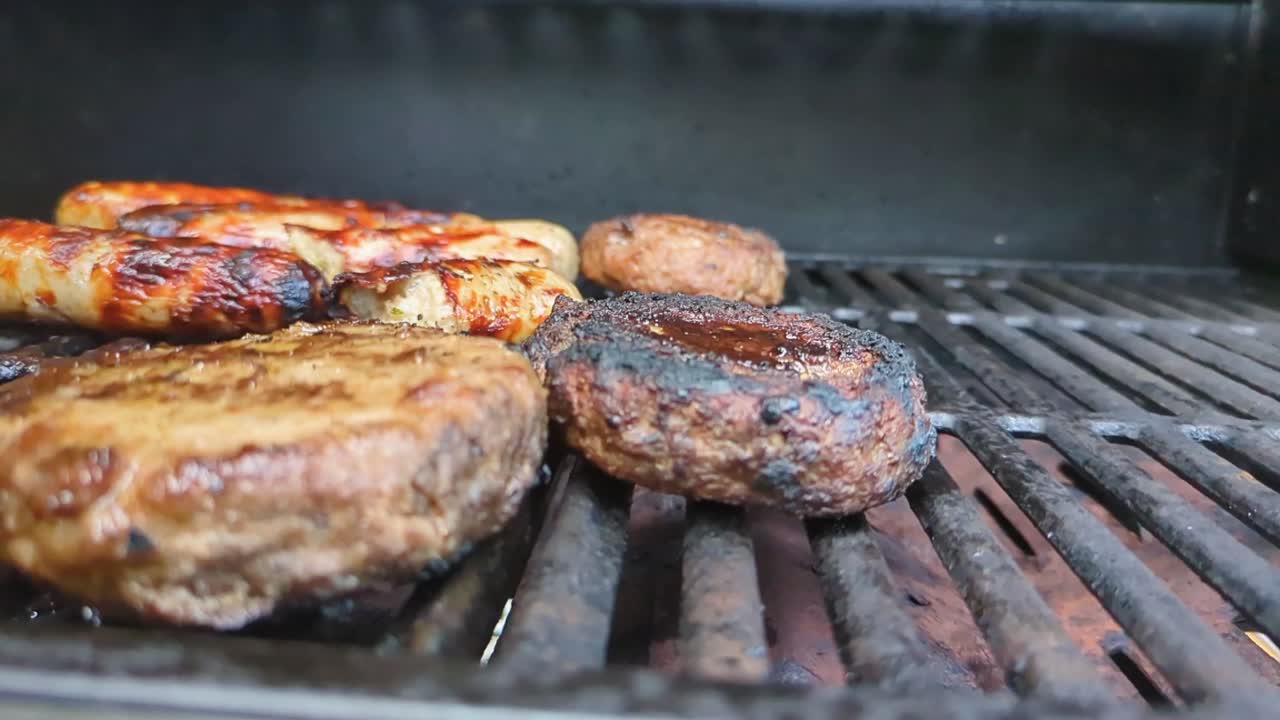 Hamburger di manzo affumicato al BBQ e salsicce in cottura e girati