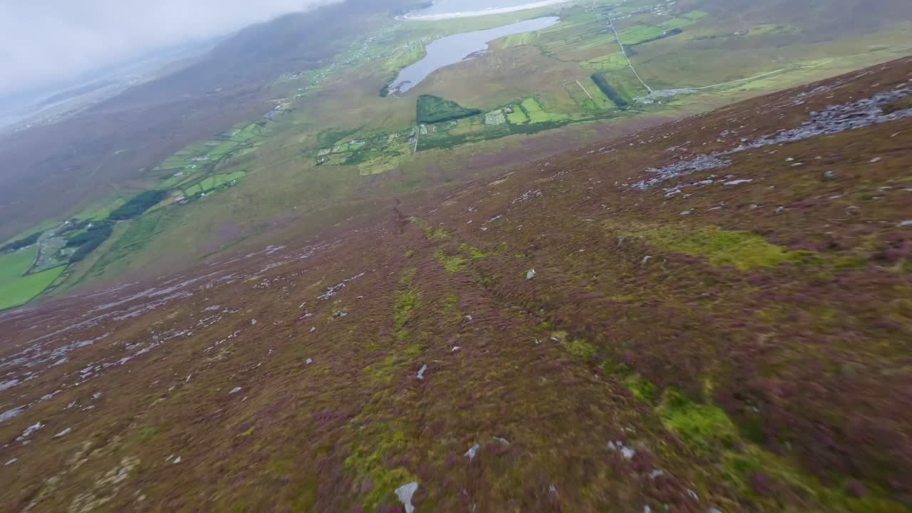 drone volando por una colina hacia el hermoso paisaje de la isla de achill