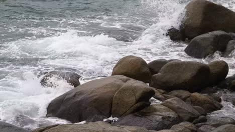 ocean waves crashing against rocks on a seashore