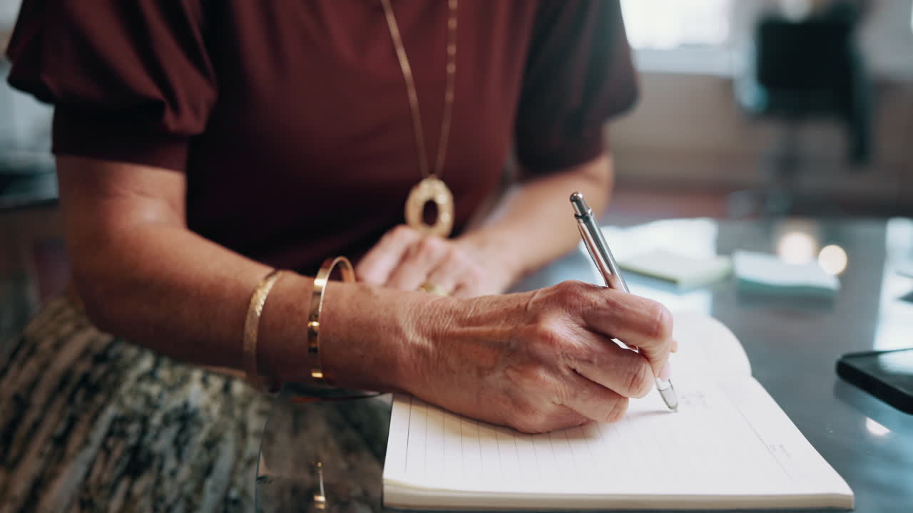 Close-Up of Person's Hands Writing in a Notebook