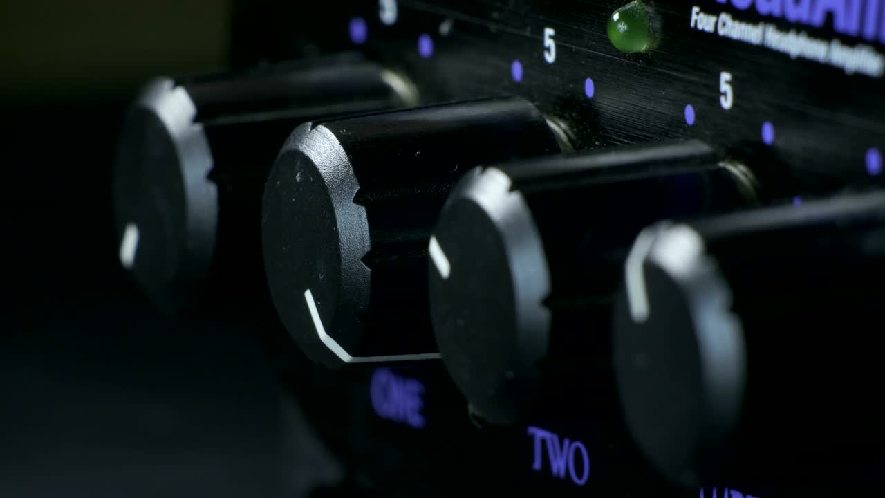 손가락으로 헤드폰 증폭기 손잡이를 회전