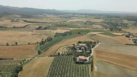 aerial images of tuscany in italy cultivated fields summer, flight over an agricultural farm with neat crops