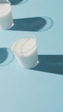 video de una fila de vasos de leche sobre un fondo azul
