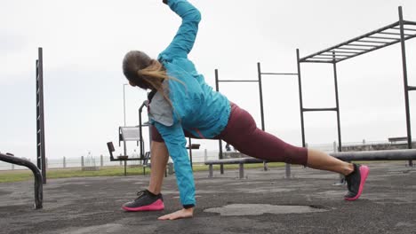 mujer caucásica deportiva haciendo ejercicio en un gimnasio al aire libre durante el día