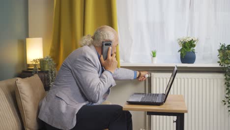 el anciano que habla por teléfono tiene frío al lado del calentador frío.