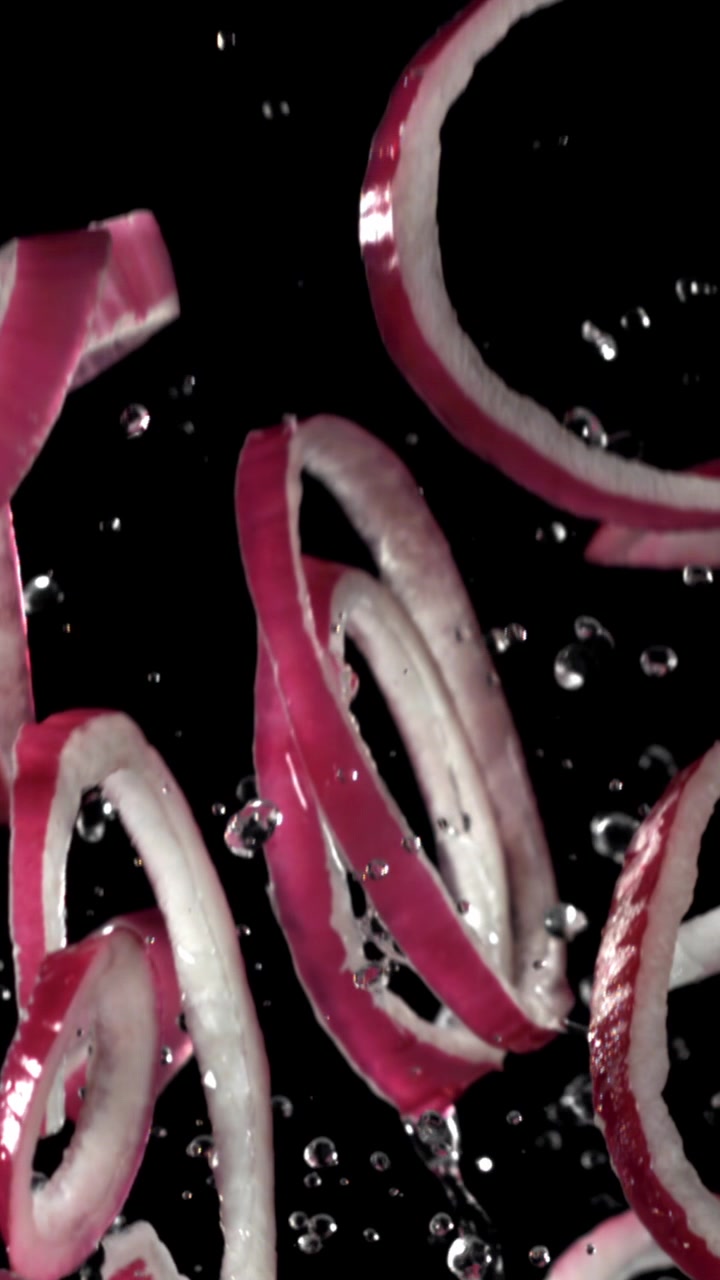 Slow Motion of Sliced Red Onion Rings Falling with Water Droplets