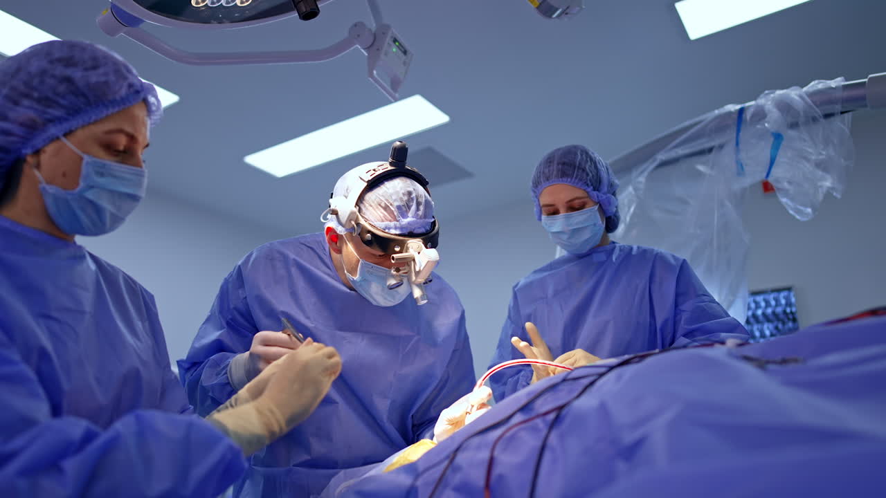 Neurosurgeon operating patient with surgical microscope. Doctor in protective mask uses microscope for delicate brain operation. Modern neurosurgical technologies in hospital setting