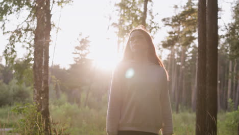 young woman in a forest at sunset