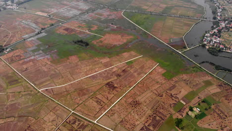 hazy rural rice paddy fields in da nang vietnam, tilt up aerial