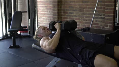 Tattooed-man-in-home-gym-close-grip-dumbbell-bench-press