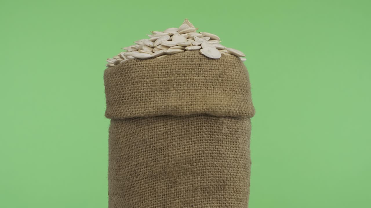 Rotating a full bag of pumpkin seeds. Close-up.