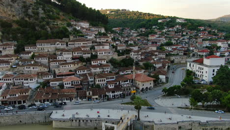 berat, the city of a thousand windows: aerial view traveling out of the famous albanian houses and the bridge during sunset