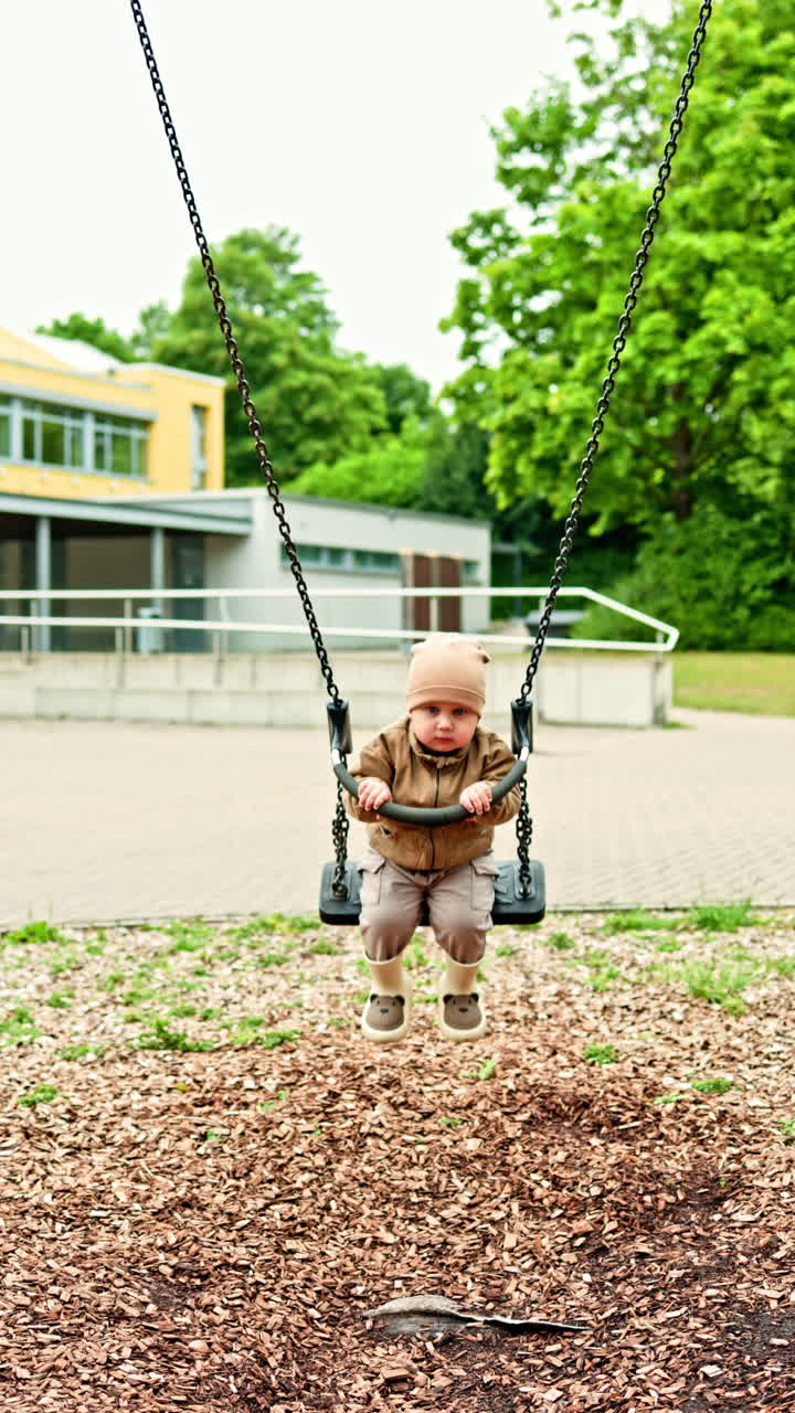 Madre e figlio felici giocano all'aperto nel parco giochi. La mamma fa dondolare il figlio sull'altalena in un parco cittadino. Concetto di maternità felice. Momenti tra mamma e figlio durante una passeggiata. Una madre amorevole trascorre del tempo con suo figlio.