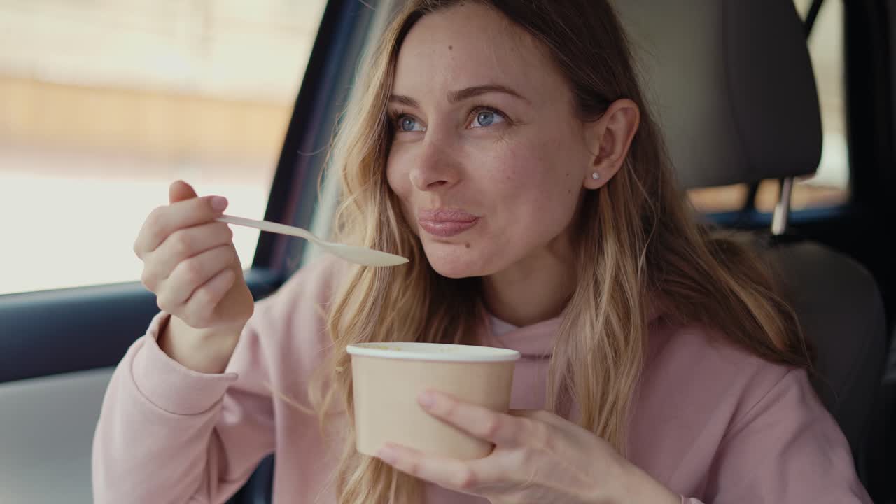 mujer teniendo su comida dentro del coche estacionado, movimiento lento