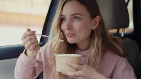 woman having her meal inside the parked car, slow mo