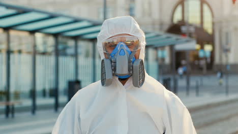 portrait of caucasian young man wearing white personal protective equipment standing outdoors and looking at camera