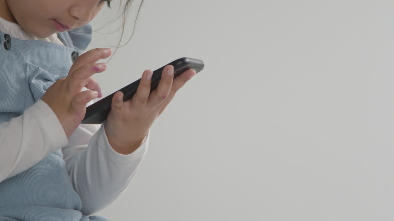 스튜디오 흰색 배경에 대해 휴대 전화에 asd 스펙트럼 게임에 어린 소녀의 닫습니다