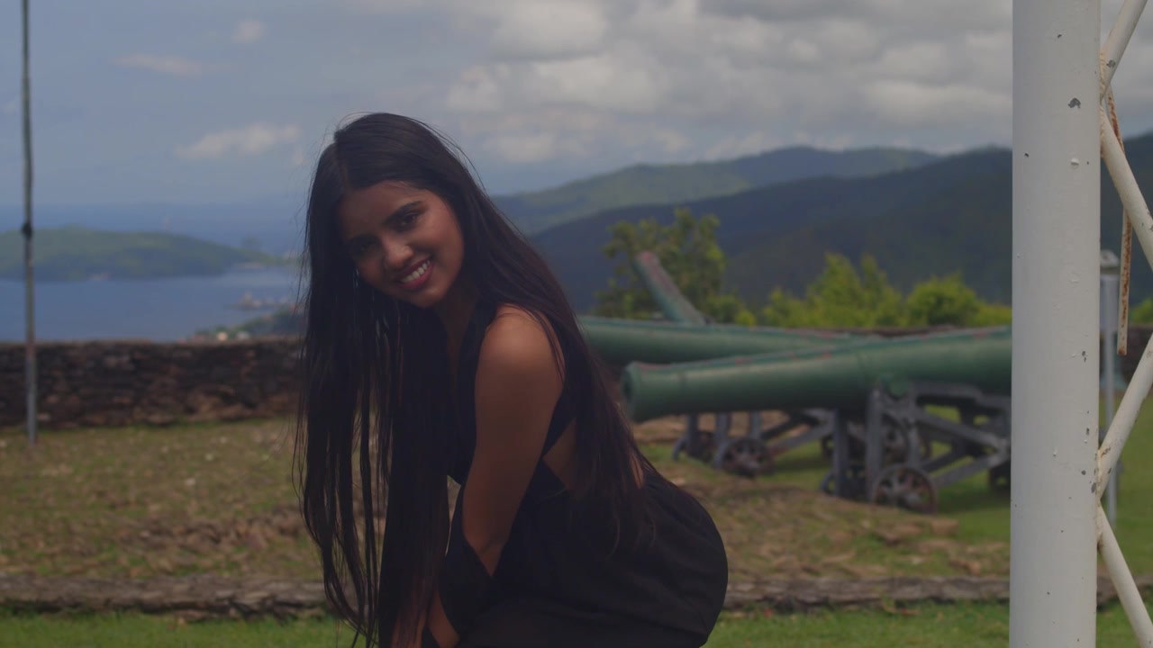 Vue de dos d'une jeune fille indienne en robe noire admirant le panorama de la ville depuis une haute forteresse.