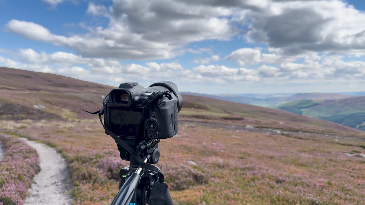 DSLR camera on tripod filming time-lapse of Loch Brandy hills under dramatic daylight clouds