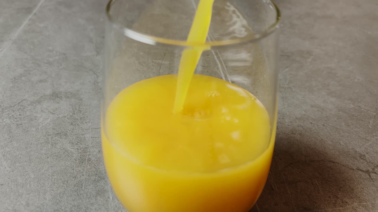 Succo d'arancia fresco versato in un bicchiere, che cattura la natura vibrante e rinfrescante di questa bevanda agli agrumi ricca di vitamine. Perfetto per uno stile di vita sano e un rinfresco mattutino.