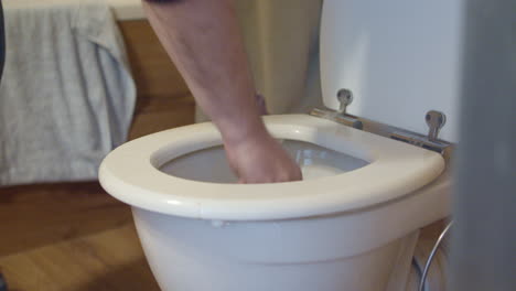 man tries to fix the clogged toilet