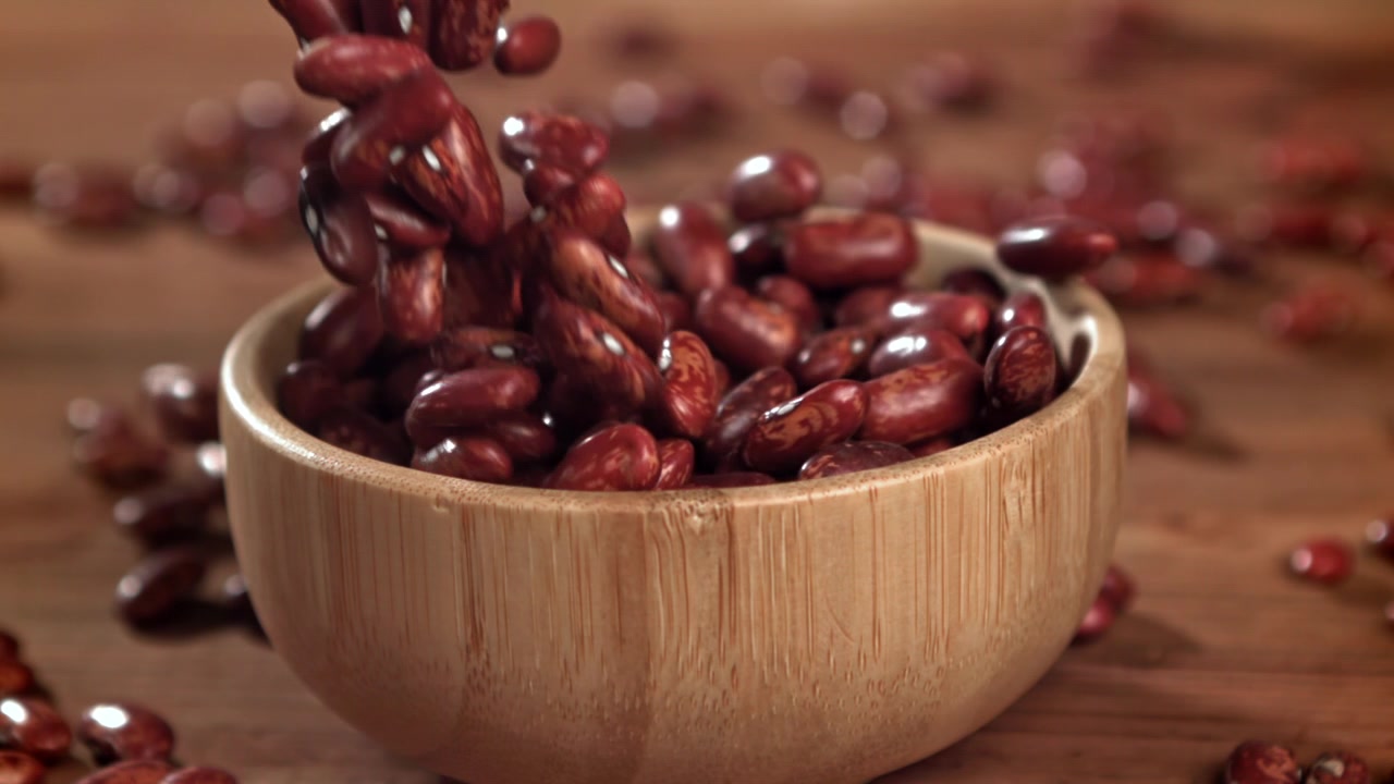 Red Kidney Beans Falling into a Wooden Bowl in Slow Motion