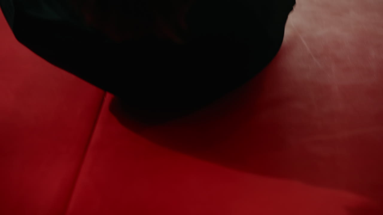 Athlete in dark sportswear captured in intense training moment with blurred close-up, showing concentration, exertion, and determination during physical workout inside bright gym environment