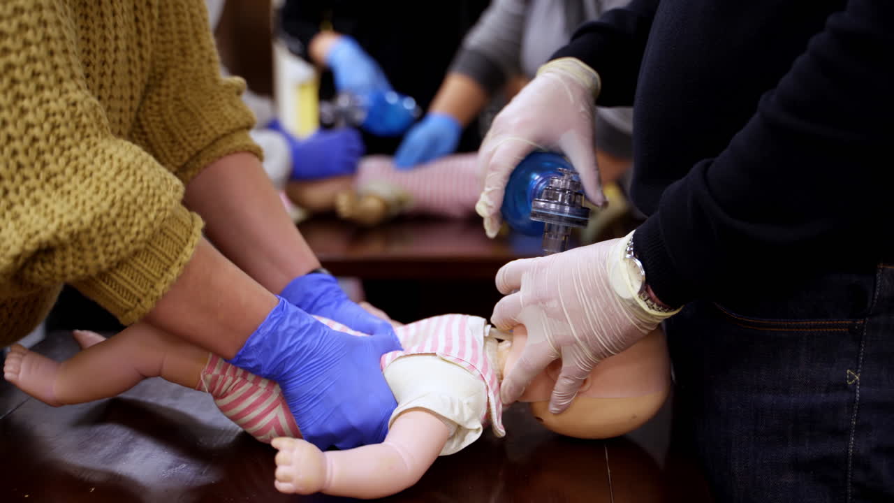 Instructor showing CPR on training doll. Woman performing CPR on baby training doll