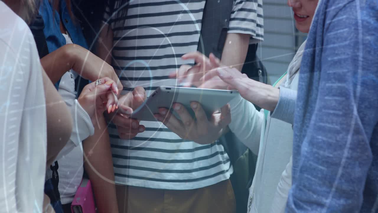 Peers crowding around, holder holding tablet while others tapping and swiping for education