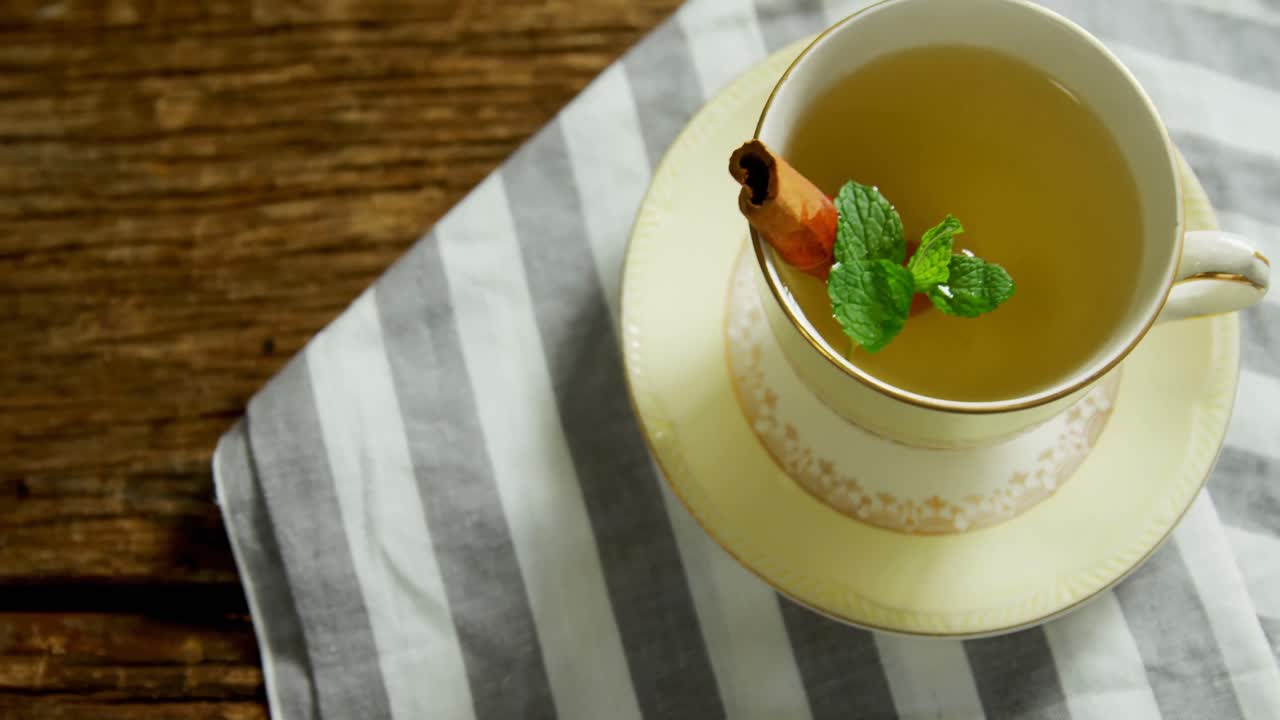 Tisana con bastoncini di cannella e erba su un panno 4k