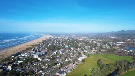 4K-aerial-drone-shot-floating-over-Seaside,-Oregon-beach-on-a-sunny-day