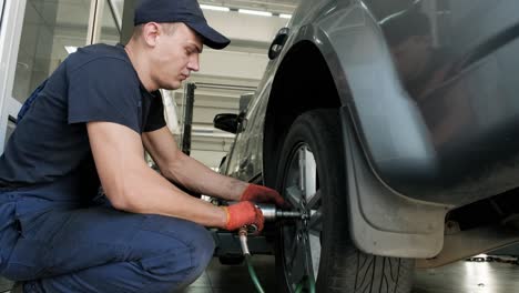 mecánico cambiando un neumático de coche