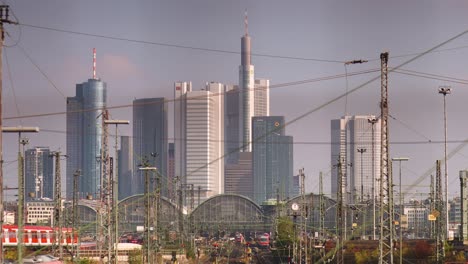 red train arrives at frankfurt rail-station, panorama skyline view, static shot