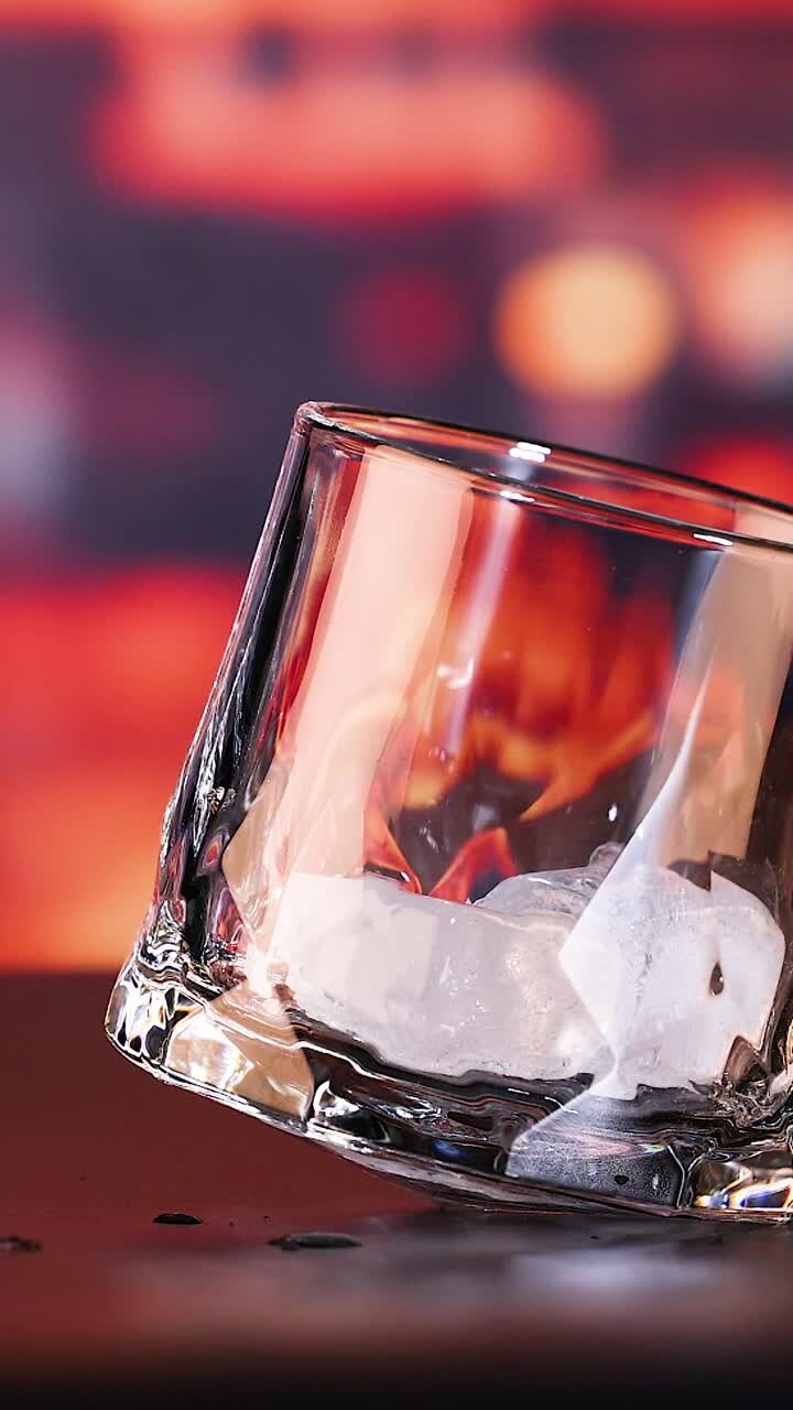 Whisky hældes i et glas med is
