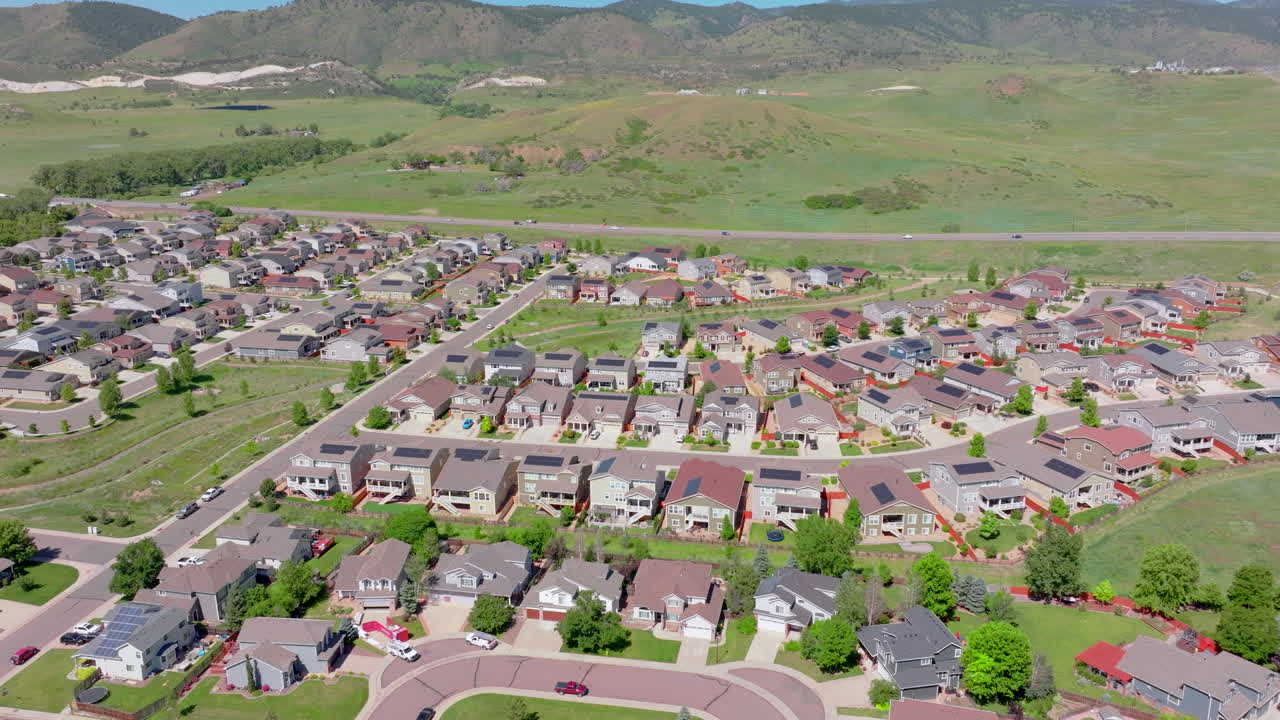 vista aérea de arriba hacia adelante del vecindario suburbano en el verano con paneles solares renovables y verdes en el techo para ayudar al clima