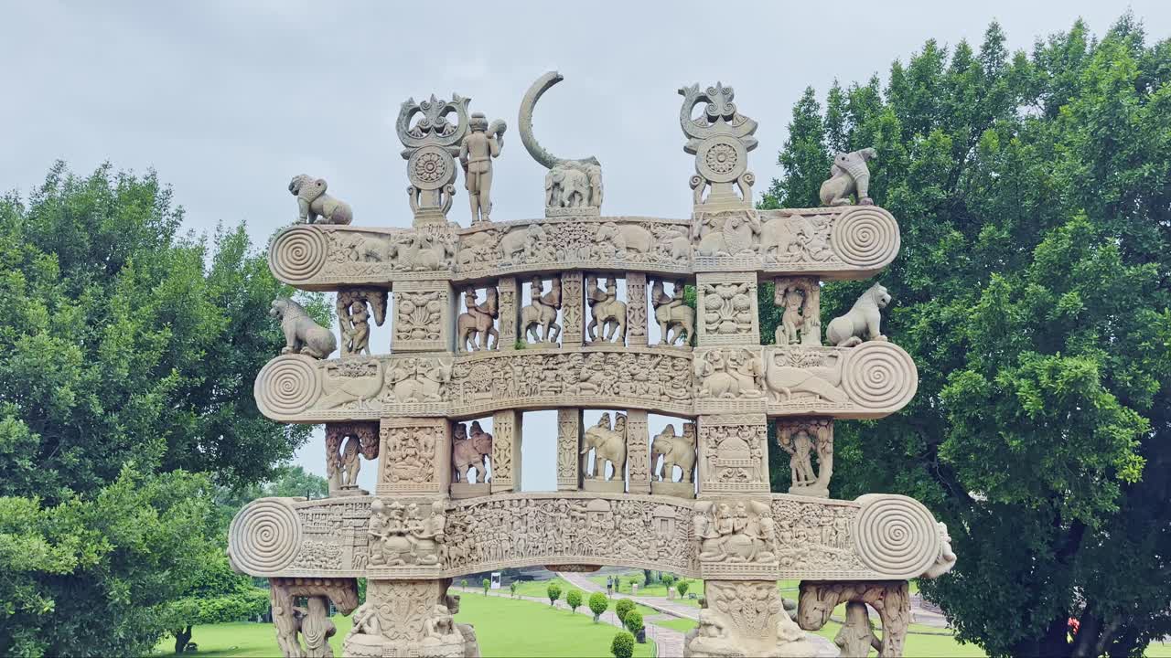 As the camera tilts up, the Torana of Sanchi Stupa reveals carvings of elephants, horse riders, lions, celestial beings, and sacred symbols, narrating stories of Buddhist faith and culture in stone
