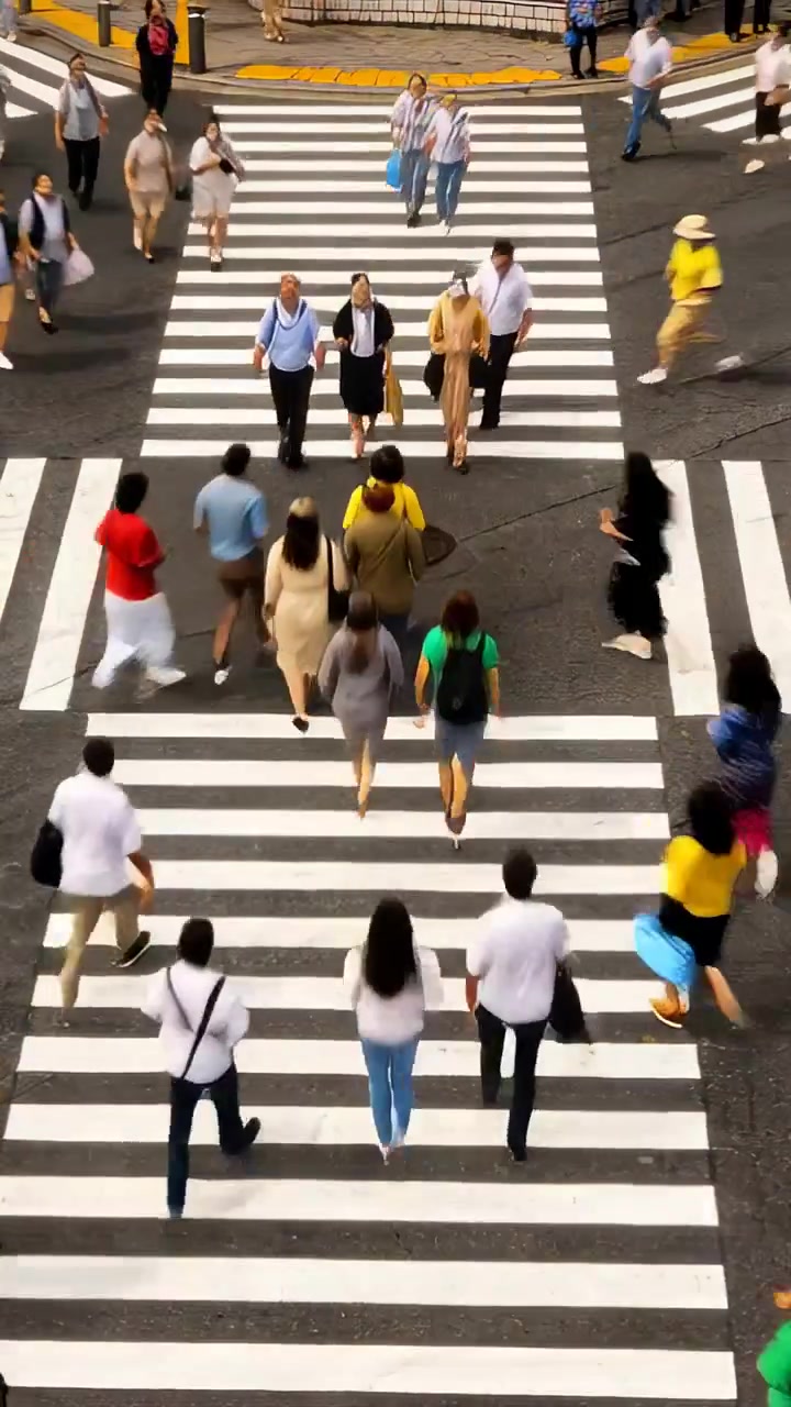 Video verticale: Lavoratori che attraversano il centro seguendo il segnale pedonale sulle strisce pedonali, in abiti da lavoro.