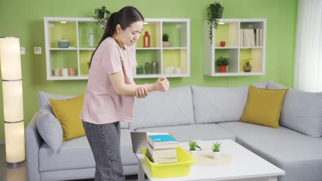 young asian woman carrying heavy load injured her arm muscles.