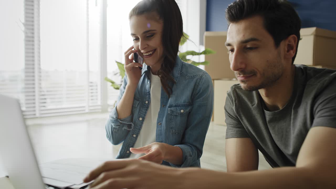 video de una pareja revisando documentos y llamando mientras se mudan.