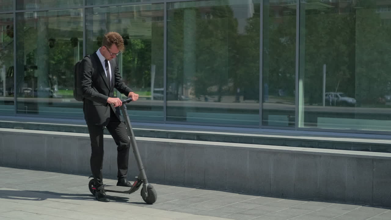 현대 건물 앞 에서 전기 스쿠터 를 타고 있는 사업가