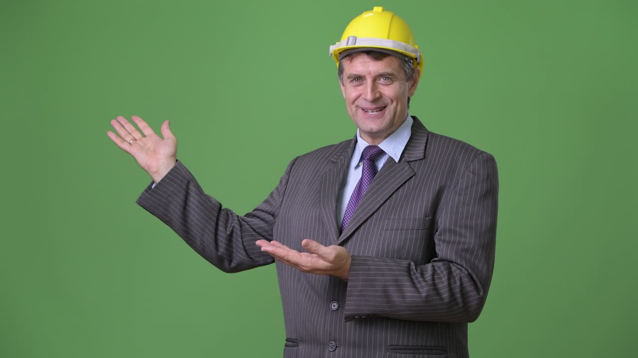 hombre de negocios maduro y guapo contra un fondo verde