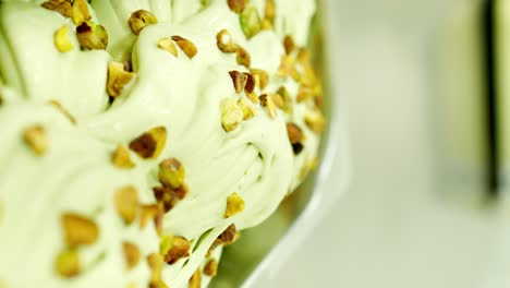 tray with creamy pistachio ice cream topped with pistachio chips, prepared in an ice cream factory