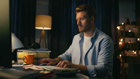 Focused-freelancer-typing-keyboard-at-home-closeup.-Serious-man-reading-computer